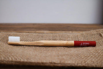 rode bamboe tandenborstel op jute zak