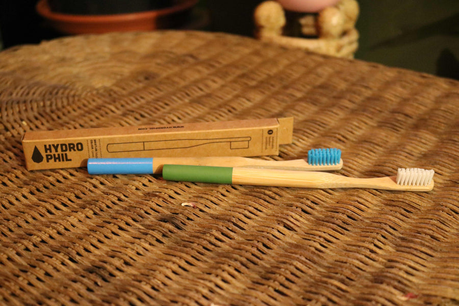 groene en blauwe bamboe tandenborstel op rieten tafel